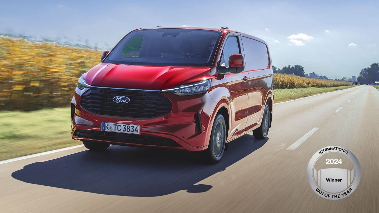 Ford E Transit Custom Double Cab roșu rulând pe șosea 